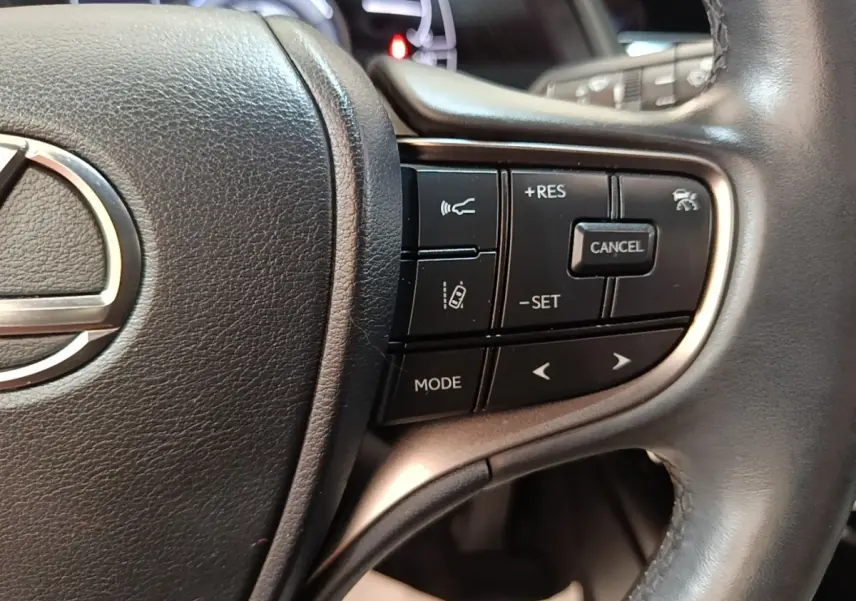 Gros plan sur le côté droit du volant cuir noir du Lexus UX 250H 2WD 2023 avec commandes de régulateur adaptatif.