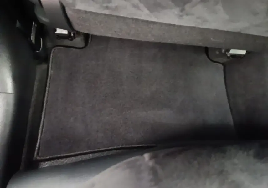 Vue rapprochée du tapis de sol noir côté passager arrière d’un Lexus UX 250H gris clair 2023.