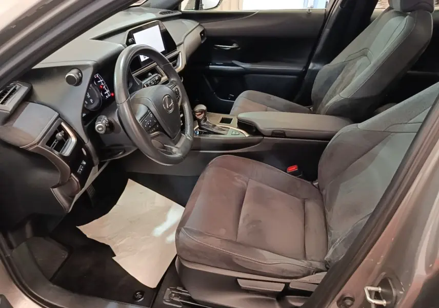Intérieur avant droit du Lexus UX 250H gris clair, volant cuir multifonctions et écran tactile central visible.