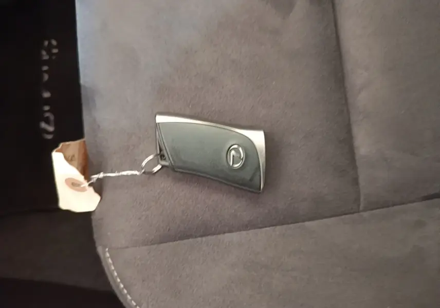 Clé de démarrage Lexus posée sur un siège en tissu gris foncé à l'intérieur du véhicule.