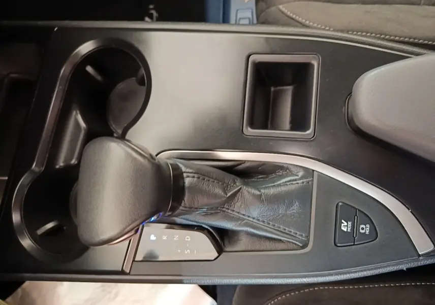 Gros plan sur la console centrale du Lexus UX 250H 2WD gris clair, avec levier de vitesses automatique et boutons EV Mode.
