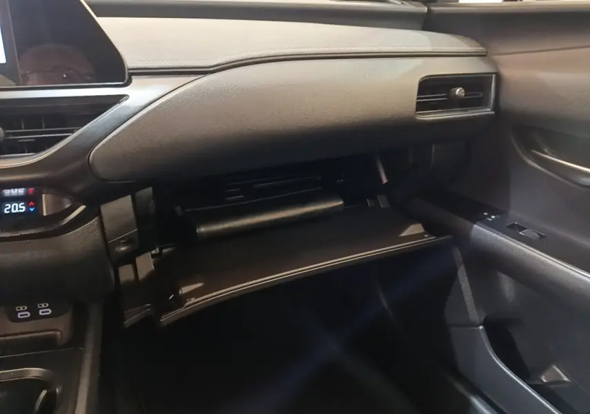 Intérieur du Lexus UX 250H 2WD Pack Business 2023, vue côté passager sur la boîte à gants ouverte et tableau de bord noir.