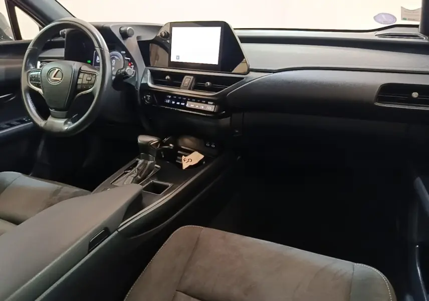 Vue intérieure avant droite du Lexus UX 250H gris clair, avec tableau de bord moderne et écran tactile central.
