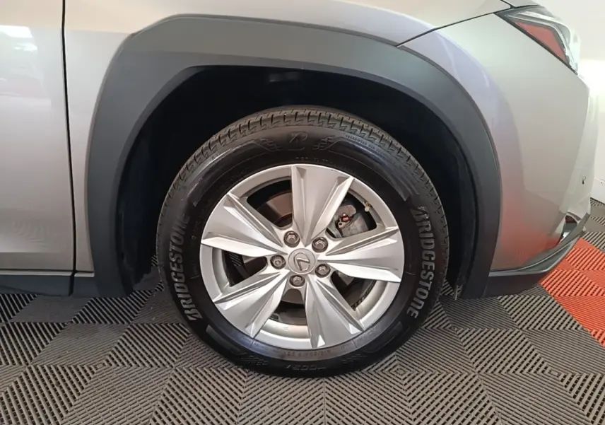 Gros plan sur la roue avant droite grise d’un Lexus UX 250H 2WD avec jante argentée et pneu Bridgestone.