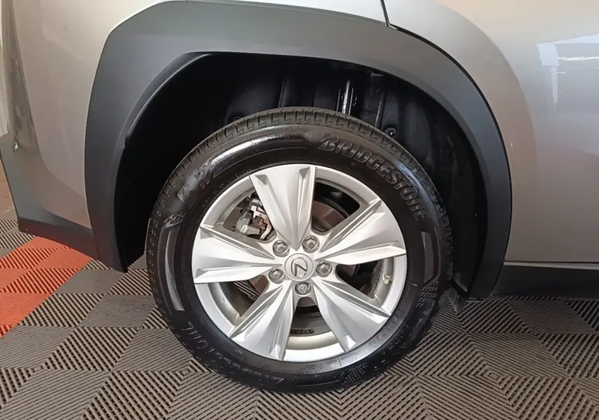 Gros plan sur la roue avant droite gris clair du Lexus UX 250H 2WD Pack Business avec jante alliage et logo Lexus.
