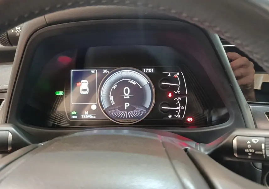 Vue rapprochée du tableau de bord numérique du Lexus UX 250H 2WD, affichage multifonctions et indicateurs visibles.
