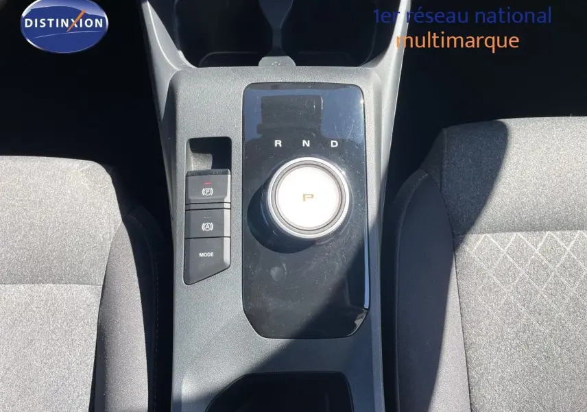 Vue plongeante sur la console centrale de la MG3 2025, avec molette de boîte auto et sièges tissu gris.