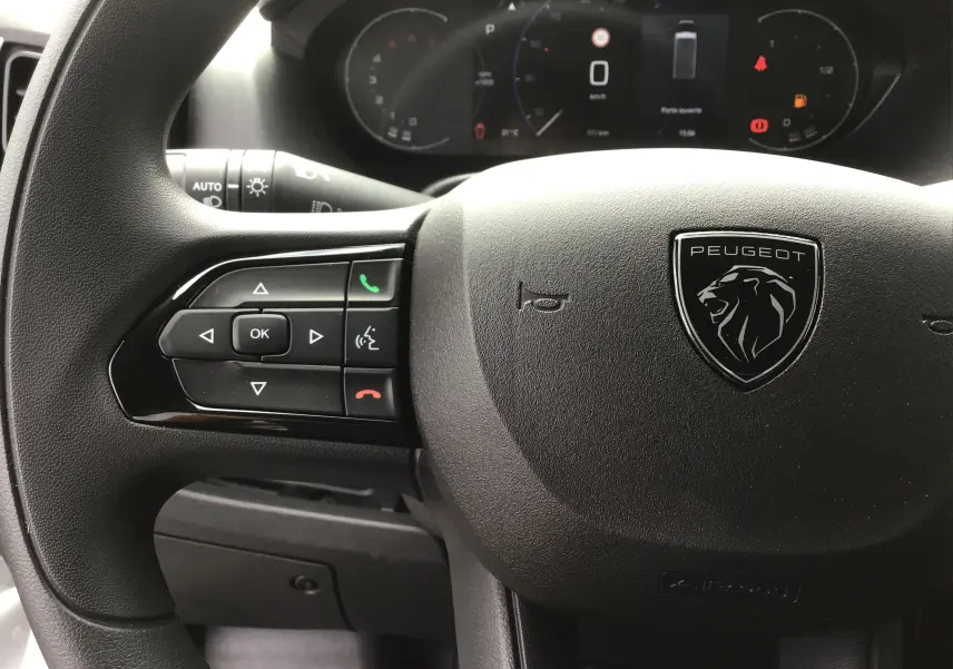 Vue rapprochée du volant Peugeot avec commandes intégrées et tableau de bord numérique du Boxer Fourgon blanc 2025.