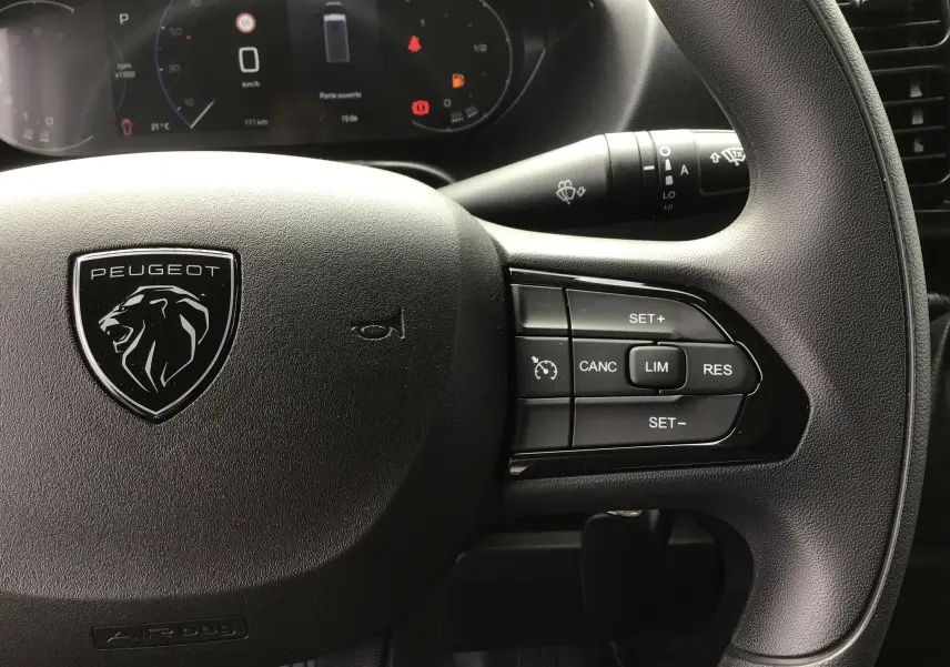 Gros plan sur le volant noir du Peugeot Boxer Fourgon 2025 avec commandes de régulateur et tableau de bord numérique.