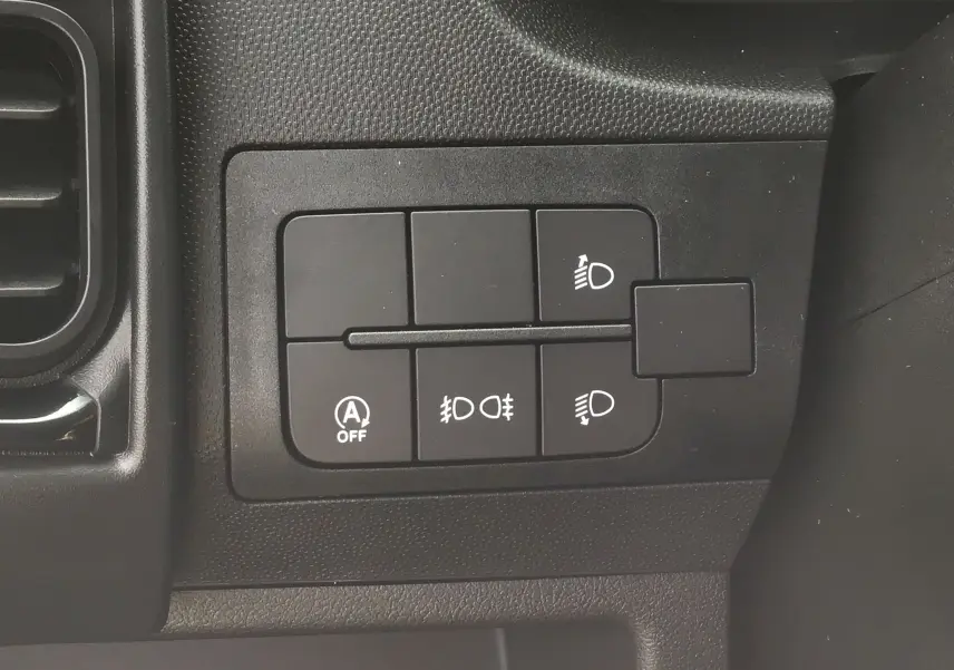 Gros plan sur les commandes d'éclairage noires du tableau de bord du Peugeot Boxer Fourgon blanc 2025.