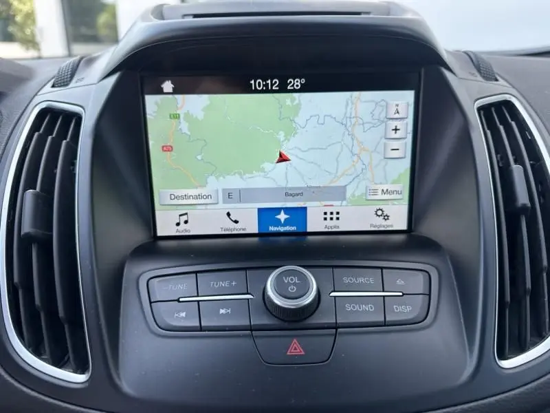 Écran tactile de navigation du Ford C-MAX 2017 avec commandes audio intégrées et ventilation latérale noire.