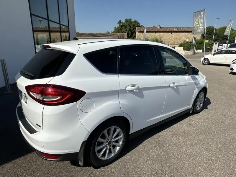 Vue 3/4 arrière droite d'un Ford C-MAX blanc 2017, finition Titanium, stationné en extérieur au soleil.