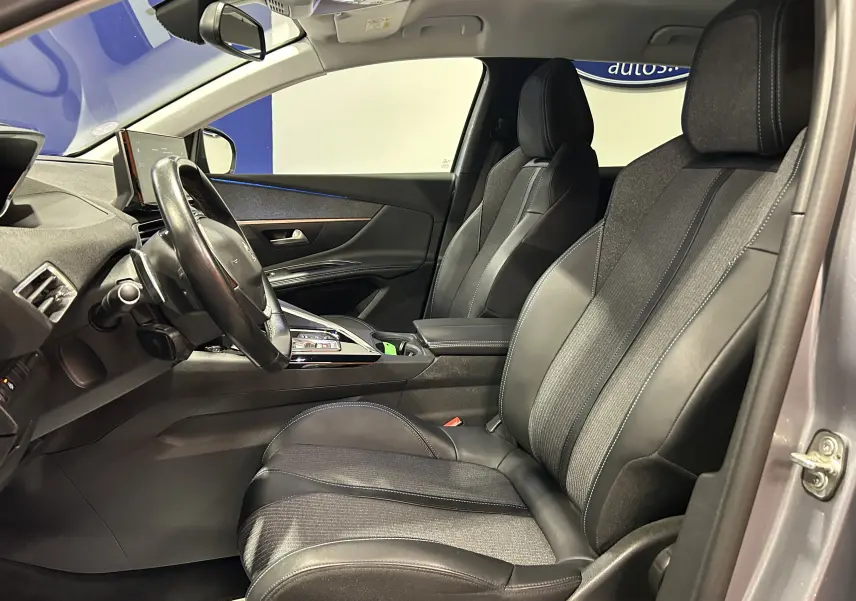 Vue intérieure côté conducteur du Peugeot 3008 gris Artense, montrant les sièges en cuir et tissu avec tableau de bord moderne.
