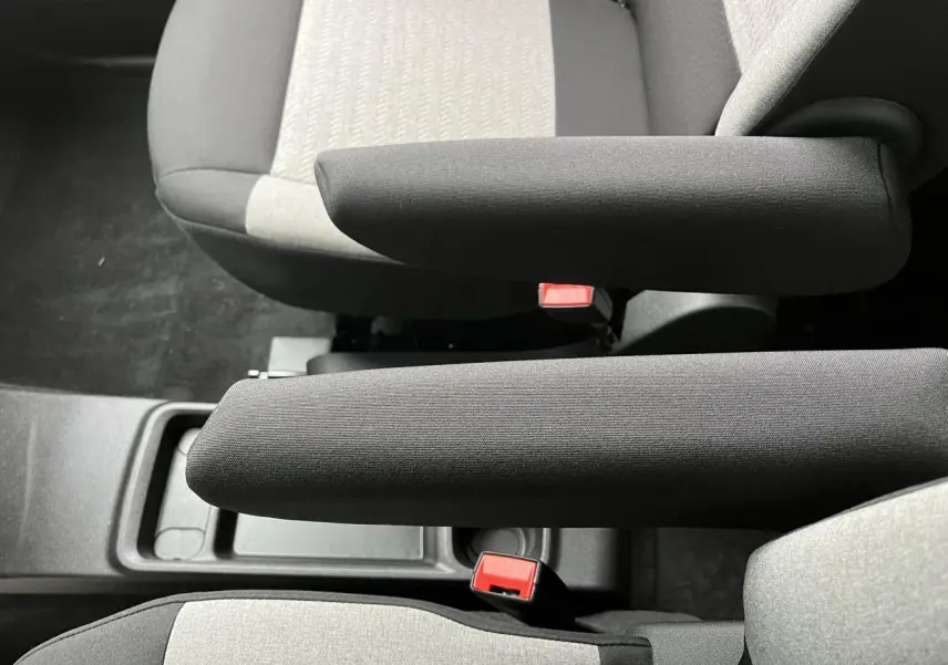 Vue rapprochée des accoudoirs noirs et des sièges gris clair du Citroën Berlingo Multispace 2025.