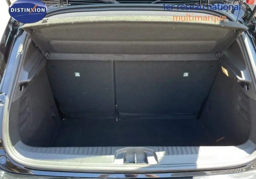 Coffre ouvert de Renault Clio noir étoile métal, vue arrière montrant l’espace de rangement vide et la garniture intérieure.