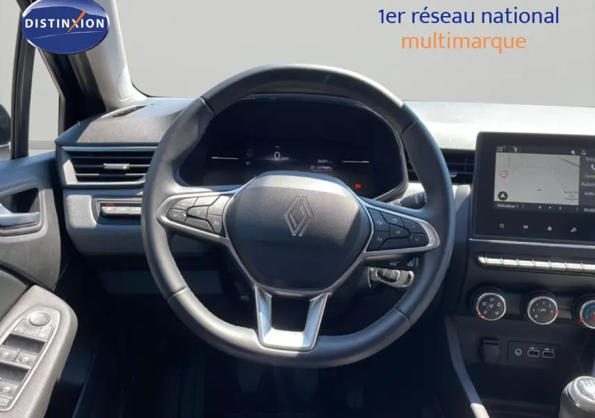 Vue intérieure centrée sur le volant Renault Clio 2025, tableau de bord numérique et écran tactile moderne.