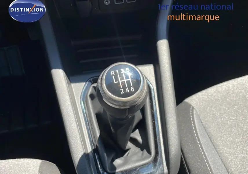 Le levier de vitesse manuel noir de la Renault Clio V BluedCi 100ch Evolution vu de dessus, avec coutures visibles sur les sièges.