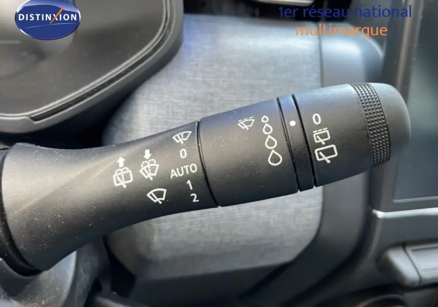 Gros plan sur la manette de commande des essuie-glaces dans l’habitacle d’une Renault Clio noire étoile métal.