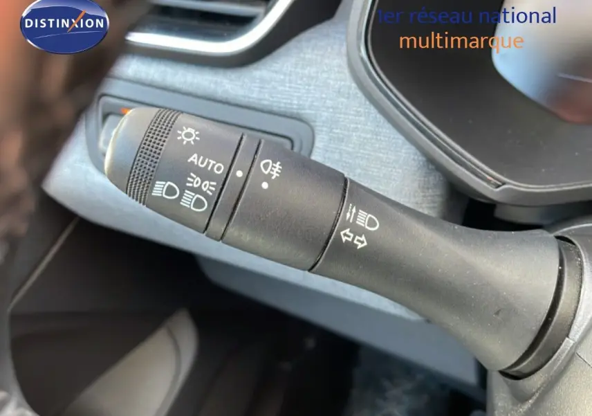 Gros plan sur la commande des phares et clignotants dans l'habitacle d'une Renault Clio noire étoile métal 2025.