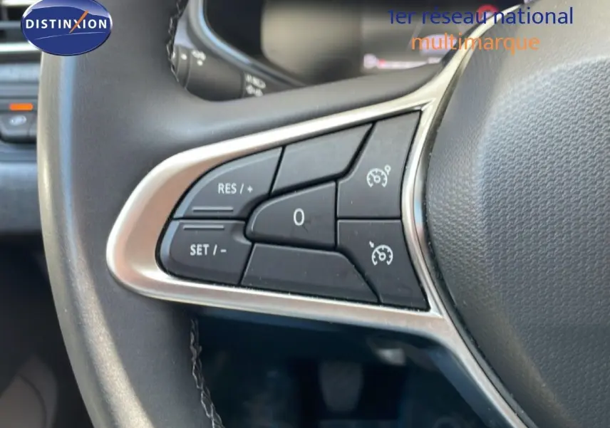 Gros plan sur les commandes de régulateur de vitesse au volant d'une Renault Clio noire étoile métal, version 2025.