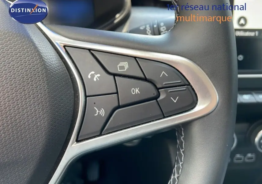 Gros plan sur les commandes multifonctions à droite du volant cuir noir de la Renault Clio V Bluetci 100ch Evolution 2025.