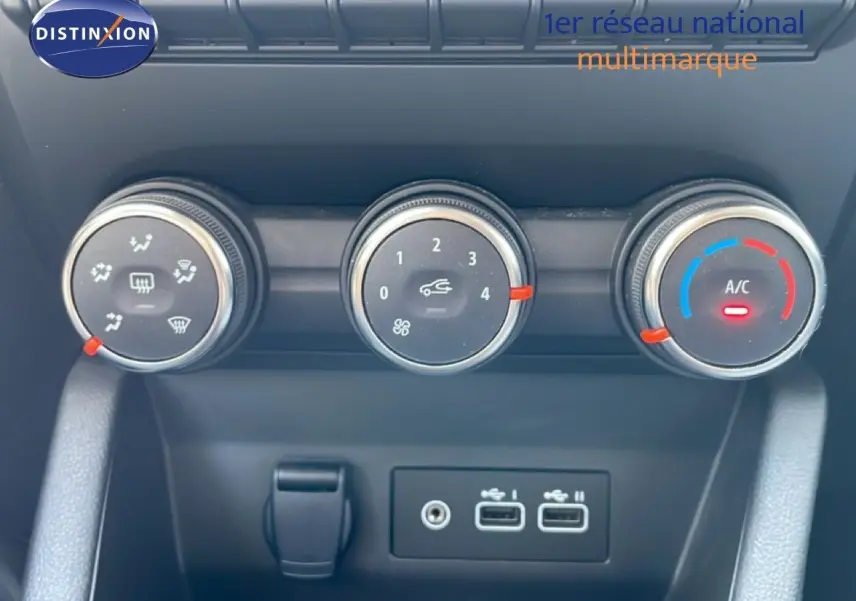 Gros plan sur les commandes de climatisation et les ports USB d'une Renault Clio noire étoile métal, version 2025.