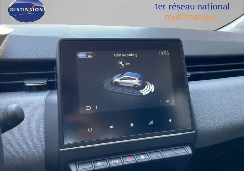 Vue rapprochée de l’écran tactile central affichant l’aide au parking dans l’habitacle d’une Renault Clio noire.