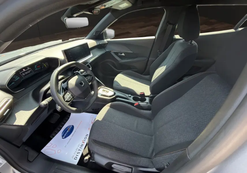 Vue intérieure côté conducteur du Peugeot 2008 Hybrid 145 e-DCS6 STYLE 2025 avec volant cuir multifonctions et écran tactile.