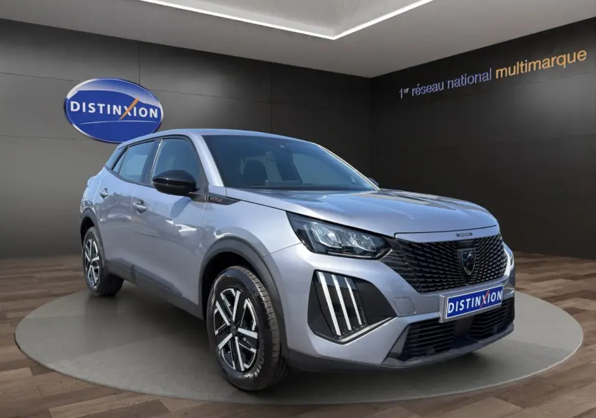 Peugeot 2008 Hybrid gris clair vue 3/4 avant droit, avec calandre noire et feux LED distinctifs.