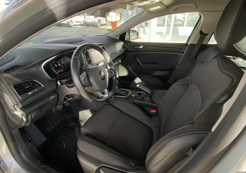 Intérieur noir de la Renault Mégane IV Berline vu côté conducteur, avec tableau de bord et volant multifonction.