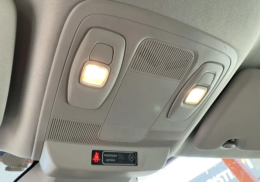 Plafonnier intérieur allumé avec indicateur d'airbag passager dans une Renault Mégane IV Berline gris, vue vers le toit.