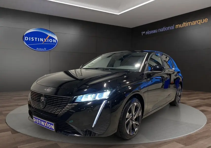 Peugeot 308 noir Perla Nera vue 3/4 avant droit, phares LED allumés et jantes alliage distinctives.