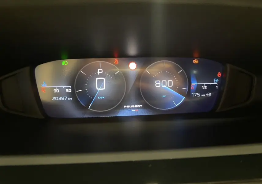 Tableau de bord numérique de Peugeot 308 noir Perla Nera 2024, affichant vitesse, régime et jauges moteur.