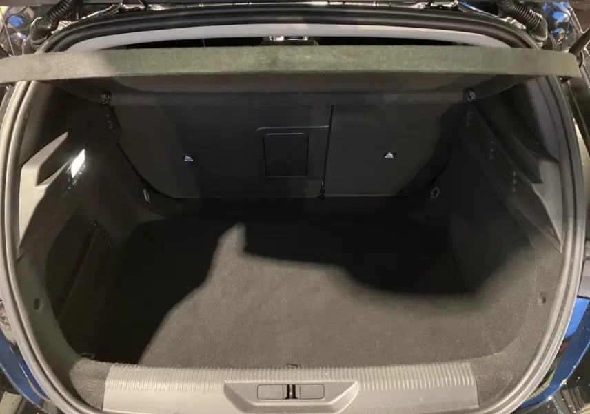 Coffre ouvert vu de dessus d'une Peugeot 308 noire Perla Nera 2024, montrant un espace de chargement propre et spacieux.