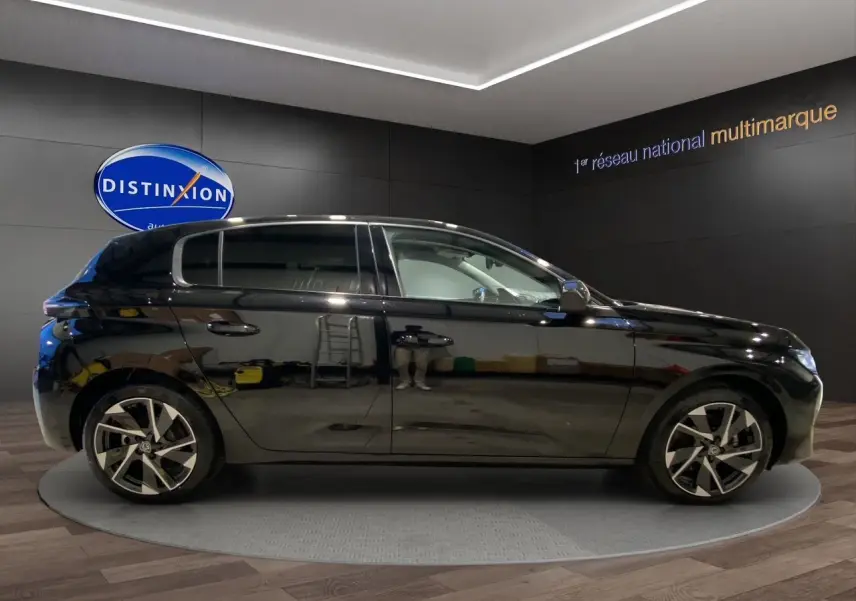 Profil droit d'une Peugeot 308 noire Perla Nera 5 portes, avec jantes alliage et intérieur clair visible.