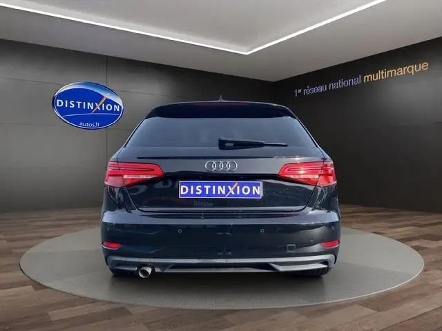 Vue arrière d'une Audi A3 Sportback noire de 2020 avec feux arrière LED et sortie d'échappement visible côté gauche.