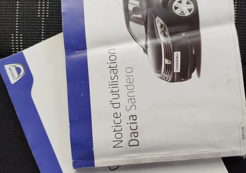 Vue de profil droit de la Dacia Sandero noire 2011, version 5 portes avec jantes alliage et calandre chromée.