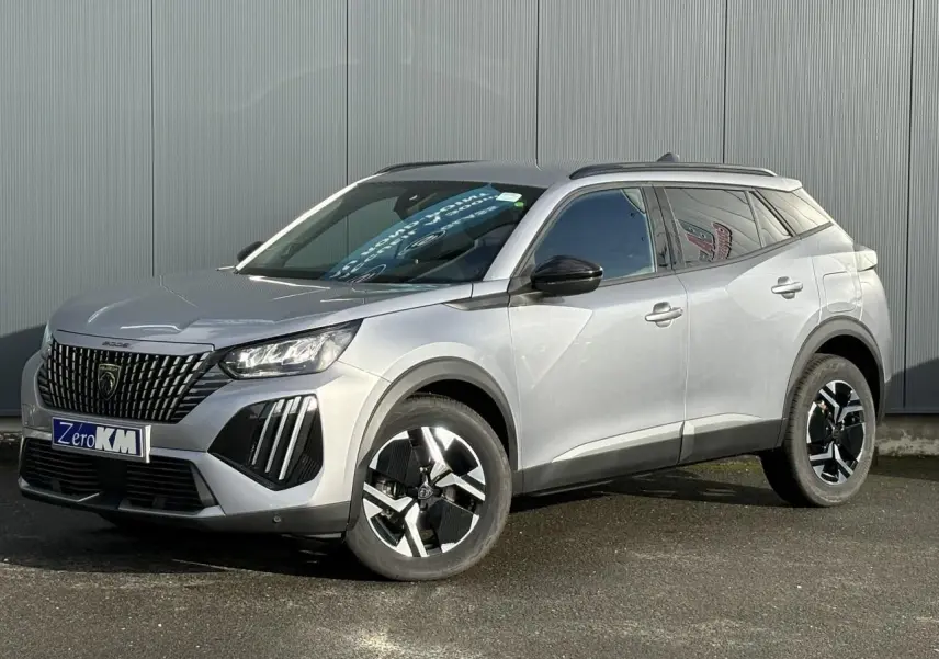 Peugeot 2008 Hybrid 145 e-DSC6 Allure gris Artense, vue 3/4 avant avec jantes alliage bi-ton et barres de toit noires.