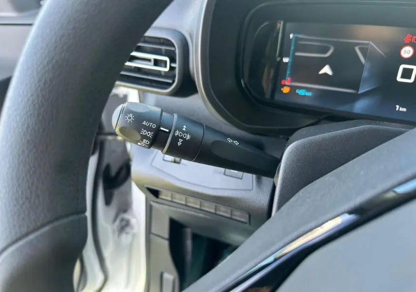 Vue intérieure de la zone de chargement arrière du Citroën Berlingo blanc Icy avec plancher bois antidérapant et parois noires.