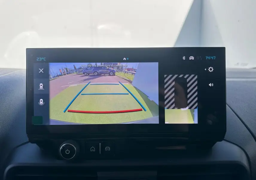 Rétroviseur droit noir brillant du Citroën Berlingo blanc Icy, vue rapprochée sur fond de carrosserie blanche.