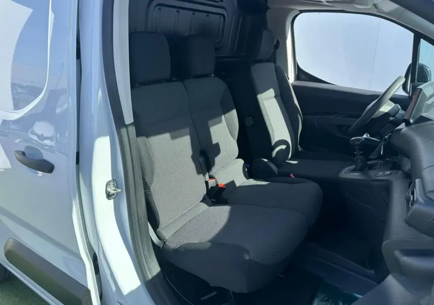 Vue intérieure côté droit du Citroën Berlingo blanc Icy, montrant les sièges avant en tissu gris et le tableau de bord.