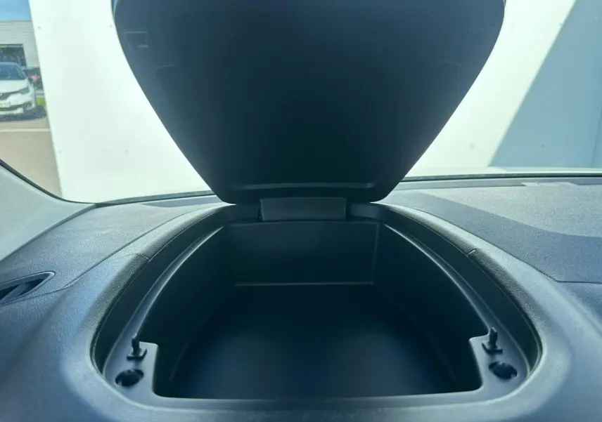 Coffre de rangement ouvert sur planche de bord noire dans l'habitacle d'un Citroën Berlingo blanc Icy.