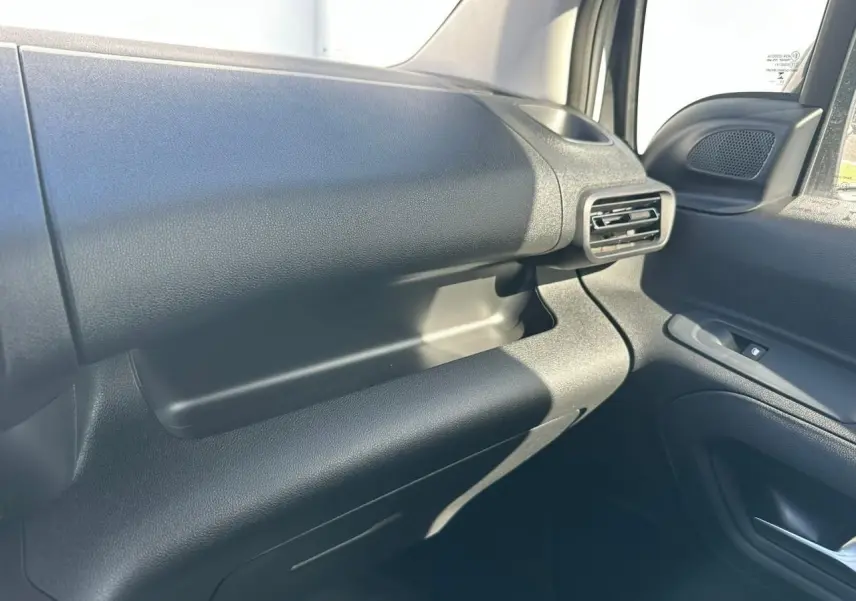 Détail de la boîte à gants fermée côté passager du Citroën Berlingo blanc Icy, vue intérieure droite.