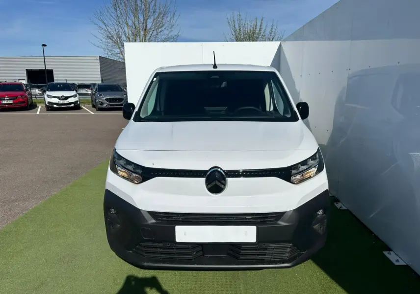 Vue de face d'un Citroën Berlingo blanc Icy avec pare-chocs noir mat et calandre épurée sur fond extérieur.