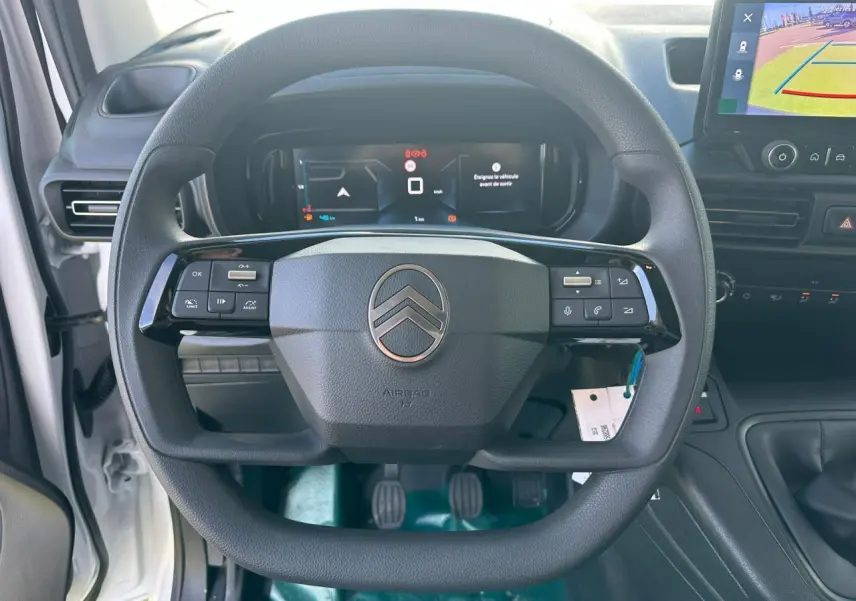 Gros plan sur le rétroviseur noir brillant côté conducteur du Citroën Berlingo blanc Icy, avec partie avant et vitre visible.