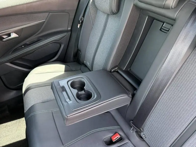 Vue intérieure côté droit de la banquette arrière noire avec accoudoir central et porte-gobelets du Peugeot 3008 Hybride Rechargeable 2024.