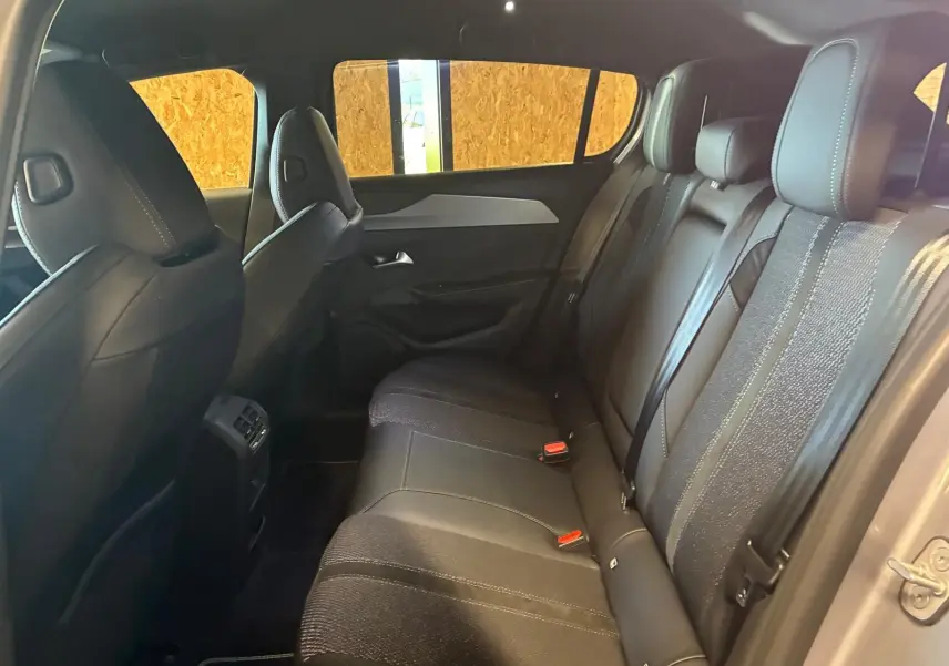 Vue intérieure arrière côté droit de la Peugeot 308 1.2 Hybrid 136 GT avec sièges noirs en tissu et cuir.