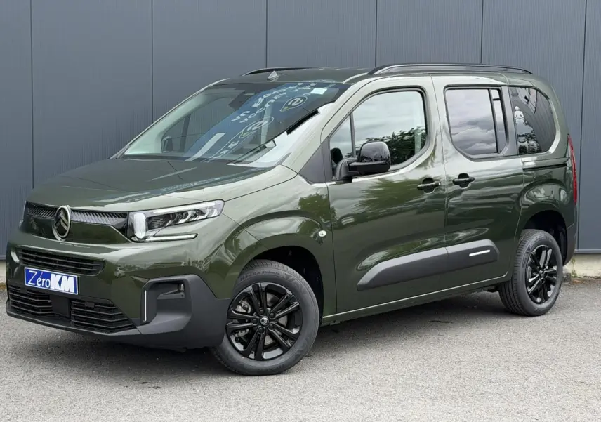 Vue 3/4 avant droit du Citroën Berlingo Multispace vert Sirkka avec jantes noires et barres de toit noires.