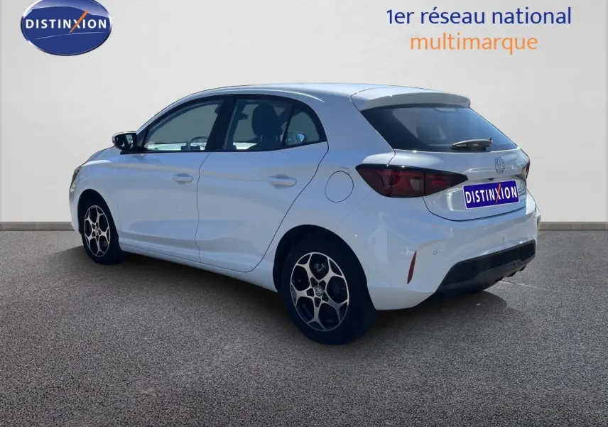 Vue 3/4 arrière droite d'une MG3 Dover White 2025, compacte hybride avec jantes alliage et feux arrière fumés.