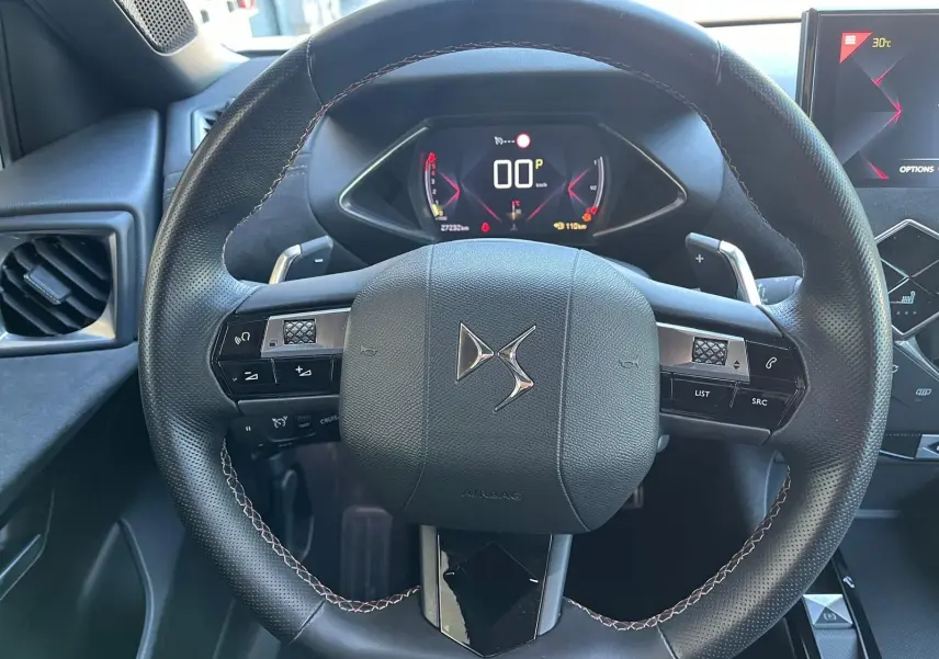 Vue rapprochée du volant DS Performance Line en cuir noir avec commandes intégrées et tableau de bord numérique.